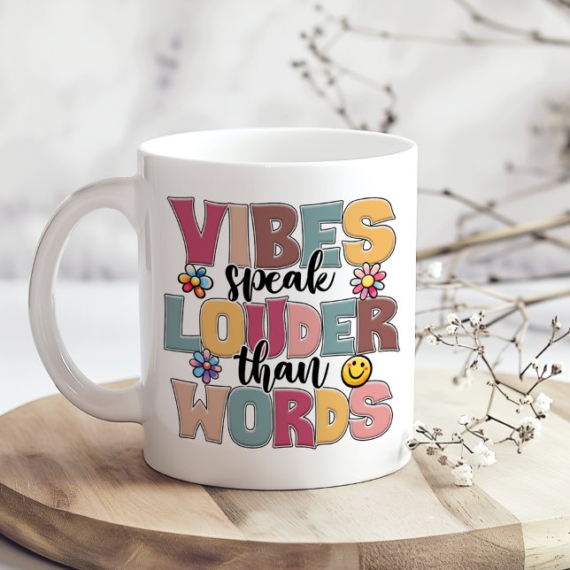 "Vibes talar högt än Ord" Hippie Colorful Kaffemugg ("Vibes Speak Louder Than Words" Hippie Colorful Coffee Mug on a boho table with tiny dry flowers)