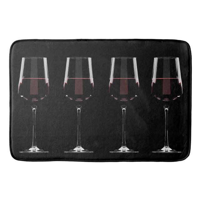 Vin-glas med rött vin på svart badrumsmatta (Framsidan)