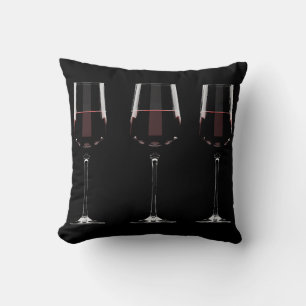 Vin-glas med rött vin på svart kudde