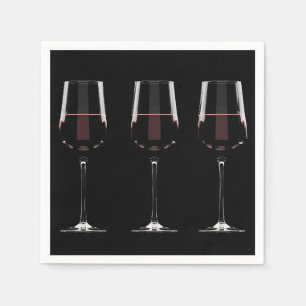 Vin-glas med rött vin på svart pappersservett
