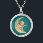 Vintage bild - Angel Sitta på Crescent Måne Silverpläterat Halsband<br><div class="desc">En söt vintage teckning. En fredlig och vänlig tittar barnlik ängel som vilar på kurvan för ett halvmånsfärande måne mot mörk grönt bakgrund.</div>