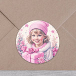 Vintage Girl in Rosa with Gift Box Runt Klistermärke<br><div class="desc">En liten vintage flicka i rosa som har en presentbox med bakgrunden snö och gräs träd. Tillsätt en söt eller nostalgisk vibe till dina julkort eller party-påsar!</div>