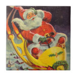 Vintage jul, Jultomten i ett rymdskepp Kakelplatta<br><div class="desc">Vintage illustrerar julbilden med en helgdag som rymmer en 50-årig Jultomten som flyger ett science fiction-rymdskepp över en sömnig stad på julen Kväll.</div>
