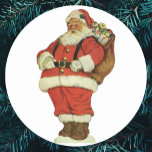 Vintage jul, Victorian Jultomten med Leksaker Runt Klistermärke<br><div class="desc">Vintagen illustrerar bilden av God jul helgdag som innehåller en jolly Jultomten med dockor och leksaker i en säck. Antique Victorian die cut.</div>