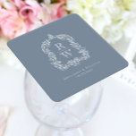 Vintage Monogram Vapensköld Namn Dusty Blue Bröllo Underlägg Papper Kvadrat<br><div class="desc">Den här eleganten har en ornerad,  snabbt vintage-inspirerad vapensköld av acanthus löv som ramar in två monogram initialer i ett öppet serif-teckensnitt,  staplas lodrätt och separeras med en tunn vågrät. Lägg till parets datum namn och bröllop nedan. Utformningen och texten är i vitt på en dammig blå bakgrund.</div>