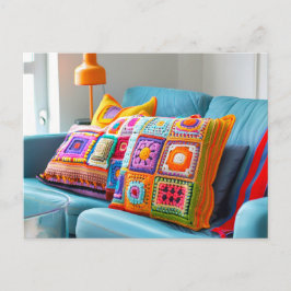 Virkade granny square kuddar som ligger på en soff vykort