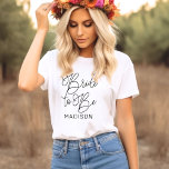 Visa som svart, modernt skript Personligt bröllp T Shirt<br><div class="desc">Modern och avslappnad chic svart kalligrafi-skript "Bride to Be" kvinnans möhippa bröllop T-skjorta har anpassningsbar text som kan vara personlig med bridens första namn. Perfekt för bruden till bäran på bakteriepartiet och bröllop helg!</div>