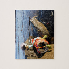 Vissende Fubby op een blikje aan de waterkant. Pussel