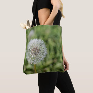 Vit dandelionblomma på grönt gräs tygkasse