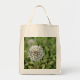 Vit dandelionblomma på grönt gräs tygkasse