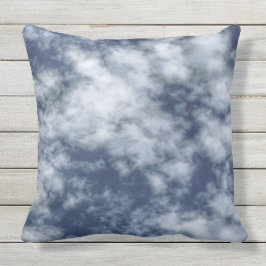 Vit fördunklar mot blå himmel på dekorativ kudde
