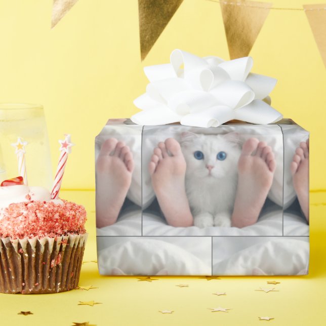Vit katt och människo fötter under en täckelse presentpapper (Födelsedagsfest)