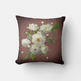 Vit ros på mörk röd kudde