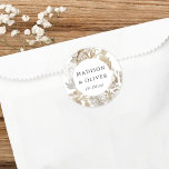 Vita bröllopsfavoriter för elegant Blommigt Runt Klistermärke<br><div class="desc">Den här vackra klistersymbolen har vackra neutralt färg-blommigtar med namn och bröllop-datum. Den här tidlösa designen är ett utmärkt val för många stilar av evenemang,  från klassiskt till biologiskt. Anpassade favoritetiketter gör ett underbart tillägg till din bröllopsmottagning eller möhippans dekoration...  och lägger till den extra speciella beröringen!</div>