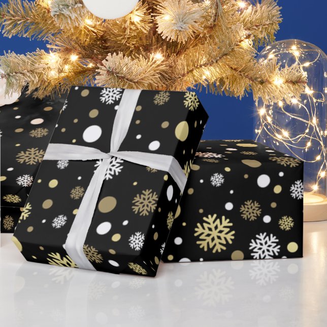 Vita falska guld snöflingor prickar på svart presentpapper (Helgdagar)