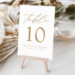 Vita och Guld Modern Elegance Bröllop Bordsnummer<br><div class="desc">Trendig, minimalistiskt kort för bröllop-bordsnummer med guld, modernt brev med "Bord" i det moderna kalligrafiskriptet. Utformningen har en vit bakgrund eller en valfri färg. Utformningen upprepas på baksidan. Så här beställer du korten för bord: lägg till ditt namn, datum för bröllop och bordsnummer. Lägg till varje nummer i din kundvagn...</div>