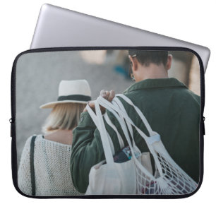 Vita påsar som bärs av människa laptop fodral