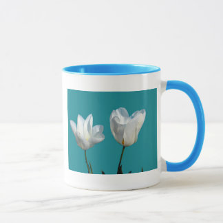 vita tulpanblommor på akvablå bakgrund mugg