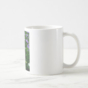 Vitkolv, lila blommor och mjölet kaffemugg