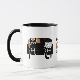 Vitsidig svart katt som sipprar på soffan mugg