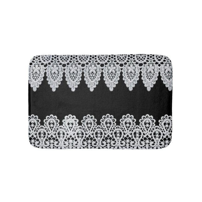 Vitsnöre bildar en delikat gräns mot svart badrumsmatta (Framsidan)