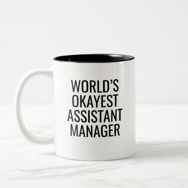 World's Okayest Assistant Manager Två-Tonad Mugg (Vänster)