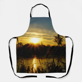 Zonsondergang bij een meertje met rietpluimen.