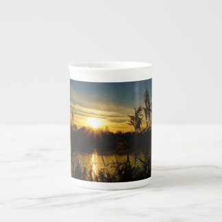 Zonsondergang bij een meertje met rietpluimen. benporslin mugg